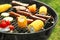 Tasty meat with vegetables and sausages being cooked on barbecue grill outdoors, closeup