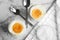 Tasty medium boiled eggs in ceramic holders on marble table, flat lay