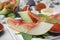 Tasty melon, jamon and figs served on white plate, closeup