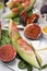 Tasty melon, jamon and figs served on white plate, closeup