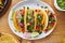 Tasty mexican tacos with beef fajita filling served with salsa and guacamole in flat lay composition