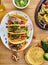 Tasty mexican tacos with beef fajita filling served with salsa and guacamole in flat lay composition