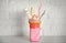 Tasty milk shake with sweets in mason jar on table