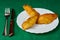 Tasty Mixed Spanish Empanadillas or spanish small pasties on a dish with silver cutlery on a tablecloth