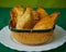 Tasty Mixed Spanish Empanadillas or spanish small pasties on a green background and a basket