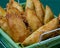 Tasty Mixed Spanish Empanadillas or spanish small pasties on a green tablecloth and a basket