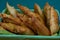 Tasty Mixed Spanish Empanadillas or spanish small pasties on a green tablecloth and a basket. Close up view