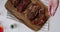 Tasty natural organic fresh piece of meat laying on wooden cutting board, seasoned with chunks of big sea salt by