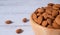 Tasty organic peeled almond snack in wooden bowl on white wooden background with copy space.Close up heap almonds shelled nut .