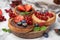 Tasty organic rusks with different toppings and ingredients on marble table, closeup