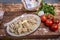 Tasty pelmeni or manti on wooden background with eggs, flour, butter