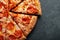 Tasty pepperoni pizza and cooking ingredients tomatoes basil on black concrete background. Top view of hot pepperoni pizza. With