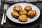 Tasty pieces of baked potatoes and salt and oil on plate