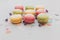 Tasty pink, yellow, green macaroons on trendy pastel gray paper