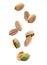 Tasty pistachio nuts falling on background