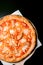 Tasty pizza with tomato sauce, mozzarella cheese, corn, chicken and pineapple on black background
