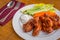 Tasty plate of glazed chicken wings with carrots, celery and dipping sauce.