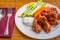 Tasty plate of glazed chicken wings with carrots, celery and dipping sauce.