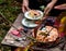 Tasty plum cake on vintage plate on brown rustic table with plates, cup, basket with plums