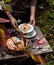 Tasty plum cake on vintage plate on brown rustic table with plates, cup, basket with plums