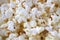 Tasty popcorn background top view, abstract corn texture