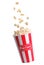 Tasty popcorn falling into cup on white background