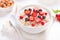 Tasty porridge with strawberry slices, black and red currants