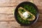 Tasty Portuguese Acorda soup with greens, garlic, bread and poached egg close-up in a plate. horizontal top view