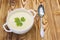 Tasty potato soup with a leaf of parsley, rustic wooden table. Potato and onion vegan, vegetarian healthy cream soup in white cera