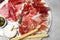 Tasty prosciutto served on grey marble table, flat lay