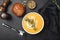 Tasty pumpkin cream soup in bowl over black background