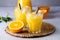 Tasty and Refreshing Orange Juice in Glasses with Black Straws on Light Gray Background Fresh Ripe Oranges Vitamin or Detox Drink