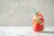 Tasty refreshing watermelon drink on marble table against grey background