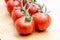 Tasty and ripe cocktail tomatoes. Vegetables sprinkled with water on a wooden kitchen table.