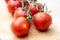 Tasty and ripe cocktail tomatoes. Vegetables sprinkled with water on a wooden kitchen table.