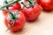 Tasty and ripe cocktail tomatoes. Vegetables sprinkled with water on a wooden kitchen table.