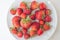 Tasty ripe strawberries on the table, summer seasonal healthy red berry on a white plate