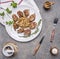 Tasty roasted pieces of pork with mushroom sauce on a white plate with herbs and vintage cutlery wooden rustic background top v