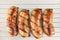 Tasty roasted sausages on wooden background