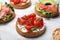 Tasty rusks with different toppings on white marble table, closeup