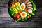 Tasty salad - roasted veal loin, avocado, boiled eggs and fresh vegetables on wooden table