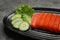 Tasty salmon slices, cucumber and lettuce on grey table, closeup. Delicious sashimi dish
