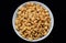 Tasty Salted Fried Peanut.  Salted fried peanuts on a plate with a blank black background.