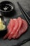 Tasty sashimi (pieces of fresh raw tuna) on black board, closeup