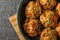 Tasty sausage balls on frying pan, top view