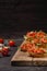 Tasty savory tomato Italian appetizers, or bruschetta, on slices of toasted baguette garnished with salad leaves, ham, chopped