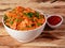 Tasty schezwan chicken fried rice with tomato sauce served in white bowl over a rustic wooden background, Indian cuisine,