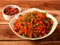 Tasty schezwan chicken fried rice with tomato sauce served in white bowl over a rustic wooden background, Indian cuisine,