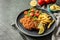 Tasty schnitzels served with potato fries, tomatoes and arugula on grey table, closeup