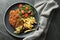 Tasty schnitzels served with potato fries, tomatoes and arugula on grey table, top view